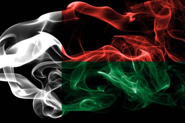 Madagaskar bayrağı renkli duman siyah arka plan üzerine izole yapılmış. Soyut ipeksi dalga arka plan.