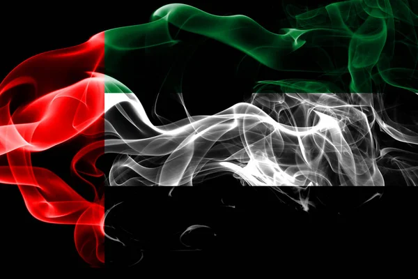 National flag of United Arab Emirates made from colored smoke isolated on black background. Abstract silky wave background.