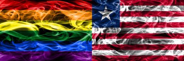 Eşcinsel vs Liberya bayrakları yan yana yerleştirilmiş duman. Eşcinsel ve Liberya ipeksi duman bayrakları renkli kalın