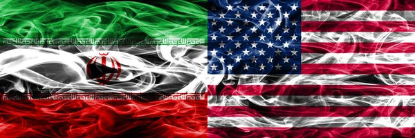 Iran vs United States of America smoke flags placed side by side. Thick colored silky smoke flags of iranian and United States of America