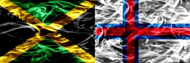 Jamaika rakip Faroe Adaları bayrakları yan yana yerleştirilmiş duman. Jamaika ve Faroe Adaları ipeksi duman bayrakları renkli kalın