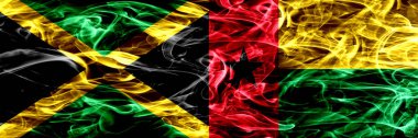Jamaika vs Gine Bissau bayrakları yan yana yerleştirilmiş duman. Jamaika ve Gine Bissau ipeksi duman bayrakları renkli kalın