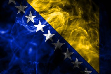 Bosna-Hersek Ulusal bayrak renkli duman izole üzerinde siyah arka plan yaptı. Soyut ipeksi dalga arka plan.