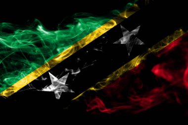 Saint Kitts ve Nevis ulusal bayrak renkli duman izole üzerinde siyah arka plan yaptı. Soyut ipeksi dalga arka plan