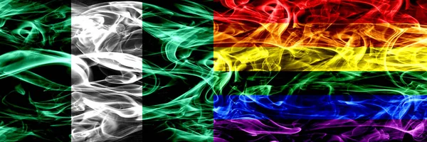 Nigeria, Nigerian vs Gay pride smoke flags placed side by side. Thick abstract colored silky smoke flags