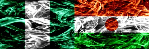 Nigeria, Nigerian vs Niger, Nigerian smoke flags placed side by side. Thick abstract colored silky smoke flags