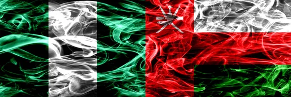 Nigeria, Nigerian vs Oman, Omani smoke flags placed side by side. Thick abstract colored silky smoke flags