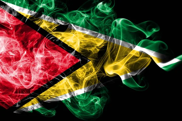 Guyanas flagga tillverkad i färgad rök isolerad på svart bakgrund. Abstrakta silkeslen våg bakgrund. — Stockfoto