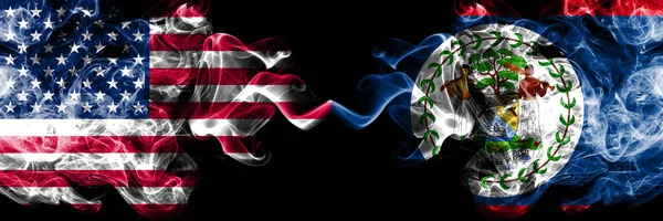 Estados Unidos vs Belice, banderas místicas ahumadas de Belice colocadas una al lado de la otra. Banderas de humo sedoso de color grueso de América y Belice, Belice —  Fotos de Stock