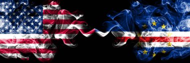 Amerika Birleşik Devletleri vs Cape Verde dumanlı mistik bayrakları yan yana yerleştirilmiş. Amerika ve Cape Verde ipeksi duman bayrakları renkli kalın