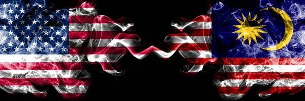 Stati Uniti d'America contro Malesia, bandiere mistiche fumose malesi affiancate. Bandiere di fumo spesse colorate di seta dell'America e della Malesia, malesi — Foto Stock
