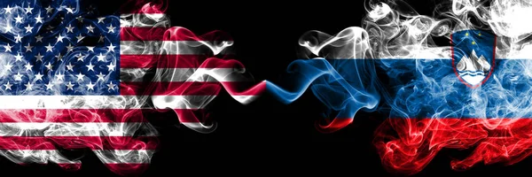 Ηνωμένες Πολιτείες της Αμερικής vs Σλοβενία, σλοβενική καπνιστή mystic σημαίες τοποθετούνται δίπλα-δίπλα. Χοντρό χρωματιστό μεταξένια καπνού σημαίες της Αμερικής και η Σλοβενία, η σλοβενική — Φωτογραφία Αρχείου