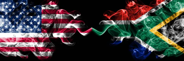 Estados Unidos da América vs África do Sul, bandeiras místicas fumegantes africanas colocadas lado a lado. Bandeiras de fumo sedoso de cor grossa da América e África do Sul, Africano — Fotografia de Stock