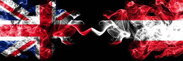 Royaume-Uni vs Autriche, drapeaux mystiques fumés autrichiens placés côte à côte. Drapeaux de fumée soyeux de couleur épaisse de Grande-Bretagne et d'Autriche, Autriche . — Photo