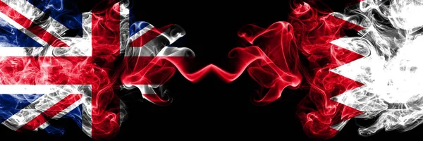 Velká Británie vs Bahrajn, Bahrani zakouřený mystic vlajky umístěné vedle sebe. Silné barvené hedvábné kouře vlajky Velké Británie a Bahrajnu, Bahrani. — Stock fotografie