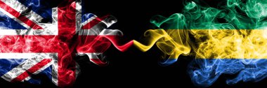 İngiltere vs Gabon, Gabon dumanlı mistik bayrakları yan yana yerleştirilmiş. Kalın ipeksi duman bayrak İngiltere ve Gabon, Gabon, renkli.