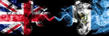 İngiltere vs Guatemala, Guatemala dumanlı mistik bayrakları yan yana yerleştirilmiş. Kalın ipeksi duman bayrak İngiltere ve Guatemala, Guatemala, renkli.