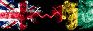 İngiltere vs Gine, Gineli dumanlı mistik bayrakları yan yana yerleştirilmiş. Kalın ipeksi duman bayrak İngiltere ve Gine, Gine, renkli.