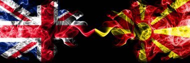 İngiltere vs Makedonya Makedon dumanlı mistik bayrakları yan yana yerleştirilmiş. Kalın ipeksi duman bayrak İngiltere ve Makedonya, Makedonca, renkli.
