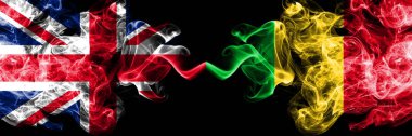 İngiltere vs Mali dumanlı mistik bayrakları yan yana yerleştirilmiş. Büyük Britanya ve Mali ipeksi duman bayrakları renkli kalın.