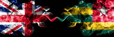 İngiltere vs Togo, Togolu dumanlı mistik bayrakları yan yana yerleştirilmiş. Kalın ipeksi duman bayrak İngiltere ve Togo, Togo, renkli.