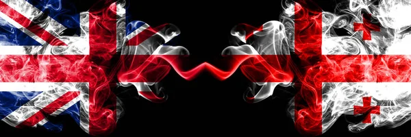 Royaume-Uni vs Géorgie, drapeaux mystiques fumés géorgiens placés côte à côte. Drapeaux de fumée soyeux de couleur épaisse de Grande-Bretagne et de Géorgie, Georgienne . — Photo
