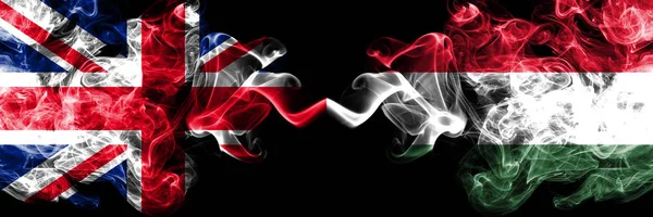 Nederland vs Hongarije, Hongaarse rokerige mystic vlaggen naast elkaar geplaatst. Dikke gekleurde zijdeachtige rook vlaggen van Groot-Brittannië en Hongarije, Hongaars. — Stockfoto