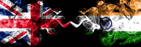 Reino Unido vs India, banderas místicas indias colocadas una al lado de la otra. Banderas de humo sedoso de colores gruesos de Gran Bretaña e India, India . — Foto de Stock