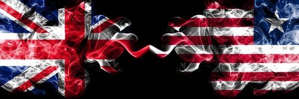 Reino Unido vs Libéria, bandeiras místicas de fumo liberiano colocadas lado a lado. Bandeiras de fumo sedoso de cor grossa da Grã-Bretanha e Libéria, Libéria . — Fotografia de Stock