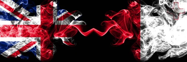 イギリス対マルタ、マルタの煙のような神秘的なフラグを並べて。イギリス、マルタ、マルタの絹のような煙の国旗色の厚. — ストック写真