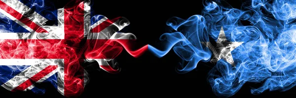 Velká Británie vs Somálsko, somálské zakouřený mystic vlajky umístěné vedle sebe. Silné barvené hedvábné kouře vlajky Velké Británie a Somálsko, Somálci. — Stock fotografie