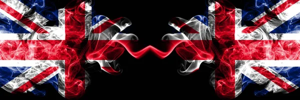 Vereinigtes Königreich gegen vereinigtes Königreich, britische rauchige mystische Flaggen nebeneinander. dicke farbige seidene Rauchfahnen von Großbritannien und dem Vereinigten Königreich, britisch. — Stockfoto