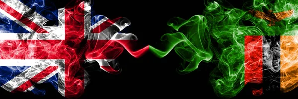 Vereinigtes Königreich gegen Sambia, sambische rauchige mystische Flaggen nebeneinander platziert. dicke farbige seidige Rauchfahnen von Großbritannien und Sambia, Sambia. — Stockfoto