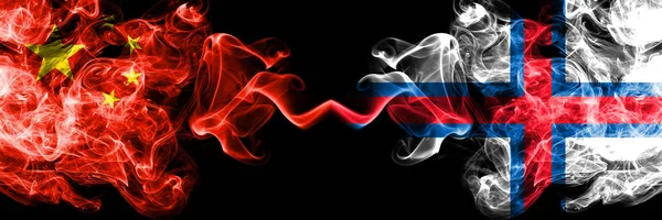 Kina vs Färöarna rök flaggor placeras sida vid sida. Tjocka färgade silkes len rök flaggor av kinesiska och Färöarna — Stockfoto