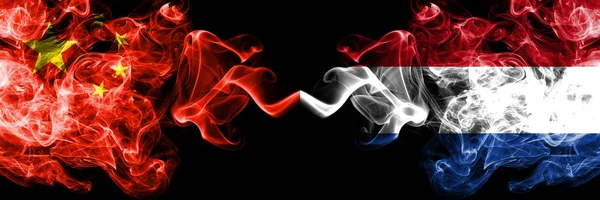 China vs Netherlands, bandiere fumogene olandesi affiancate. Bandiere di fumo spesse colorate e setose di cinesi e olandesi, olandesi — Foto Stock
