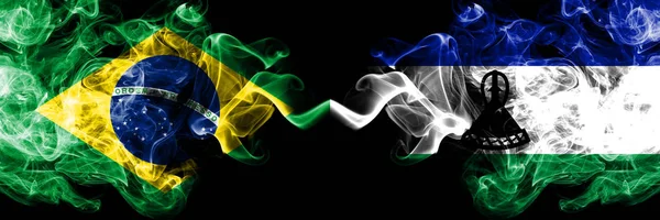 V Brazílii a Lesothských kouřových vlaječkách umístěných bok po boku. Husté barevné kouřové vlajky brazilského a Lesotha — Stock fotografie