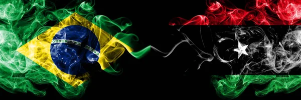 Brasile vs Libia, bandiere fumogene libiche affiancate. Bandiere di fumo color seta spesse del Brasile e della Libia, libiche — Foto Stock