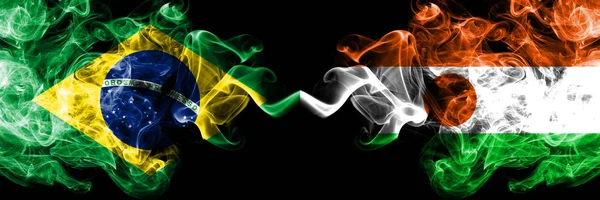 Brasile vs Niger, bandiere fumogene nigeriane affiancate. Bandiere di fumo spesse colorate di seta di Brasile e Niger, Nigeriano — Foto Stock