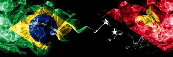 Brasile vs Papua Nuova Guinea bandiere fumogene affiancate. Bandiere di fumo spesse colorate e setose di Brasile e Papua Nuova Guinea — Foto Stock