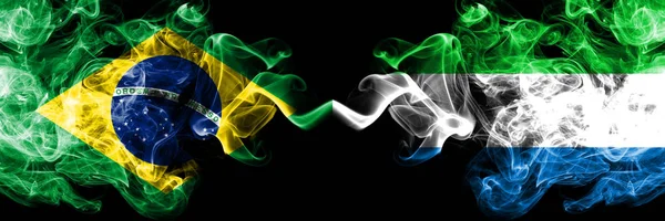 Βραζιλία vs Σιέρα Λεόνε καπνίζουν σημαίες τοποθετούνται δίπλα-δίπλα. Χοντρές σημαίες με μεταξένια καπνό της Βραζιλίας και της Σιέρα Λεόνε — Φωτογραφία Αρχείου