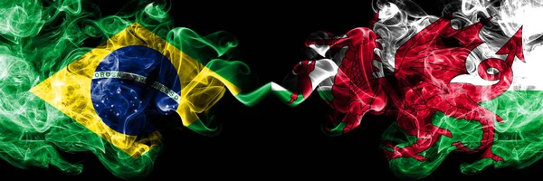Brazilië VS Wales, Welsh rook vlaggen naast elkaar geplaatst. Dikke gekleurde zijdeachtige rook vlaggen van de Braziliaanse en Wales, Welsh — Stockfoto