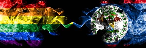 Gay vs Belize, Belizean rök flaggor placeras sida vid sida. Tjocka färgade silkes len rök flaggor av Pride och Belize, Belizean — Stockfoto