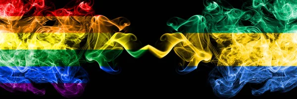 Gay vs Gabón, banderas de humo gabonesas colocadas lado a lado. Banderas de humo sedoso de color grueso de Orgullo y Gabón, Gabonés — Foto de Stock