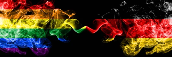 Gay vs Tyskland, tyska rök flaggor placeras sida vid sida. Tjocka färgade silkes len röker flaggor av stolthet och Tyskland, tyska — Stockfoto