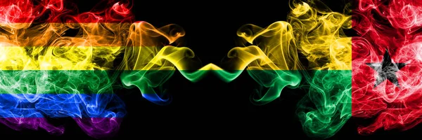 게이 vs 기니 비사우 스모크 플래그 나란히 배치. 진한 색의 실 키 스모크 플래그 오브 프라이드와 기니 비사우 — 스톡 사진