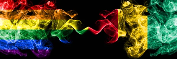 Gay vs Guinea, Guinejské kouřové vlajky umístěné vedle sebe. Tlusté barevné kouřové vlajky pýchy a Guiney, Guinejské — Stock fotografie