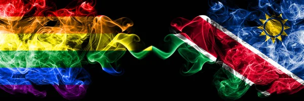 Gay vs Namibia, Namibian smoke flags placed side by side. Thick colored silky smoke flags of Pride and Namibia, Namibian — Stock Photo, Image