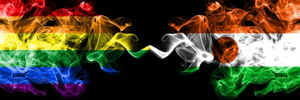 Gay vs Niger, drapeaux de fumée nigérians placés côte à côte. Drapeaux de fumée soyeuse de couleur épaisse de Fierté et Niger, Nigérian — Photo