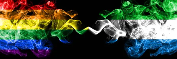 Gay vs Sierra Leone rök flaggor placeras sida vid sida. Tjocka färgade silkes len rök flaggor av Pride och Sierra Leone — Stockfoto