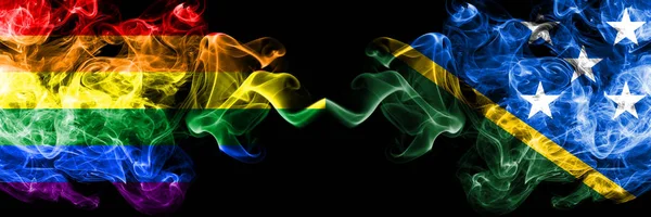 Gay vs Salomonsaarten savu liput sijoitetaan vierekkäin. Paksu värillinen silkkinen savu liput Pride ja Salomonsaarten — kuvapankkivalokuva
